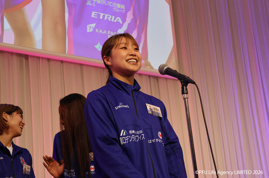 松井珠己選手(バレーボール)表彰式でマイクの前に立ち笑顔を見せる場面